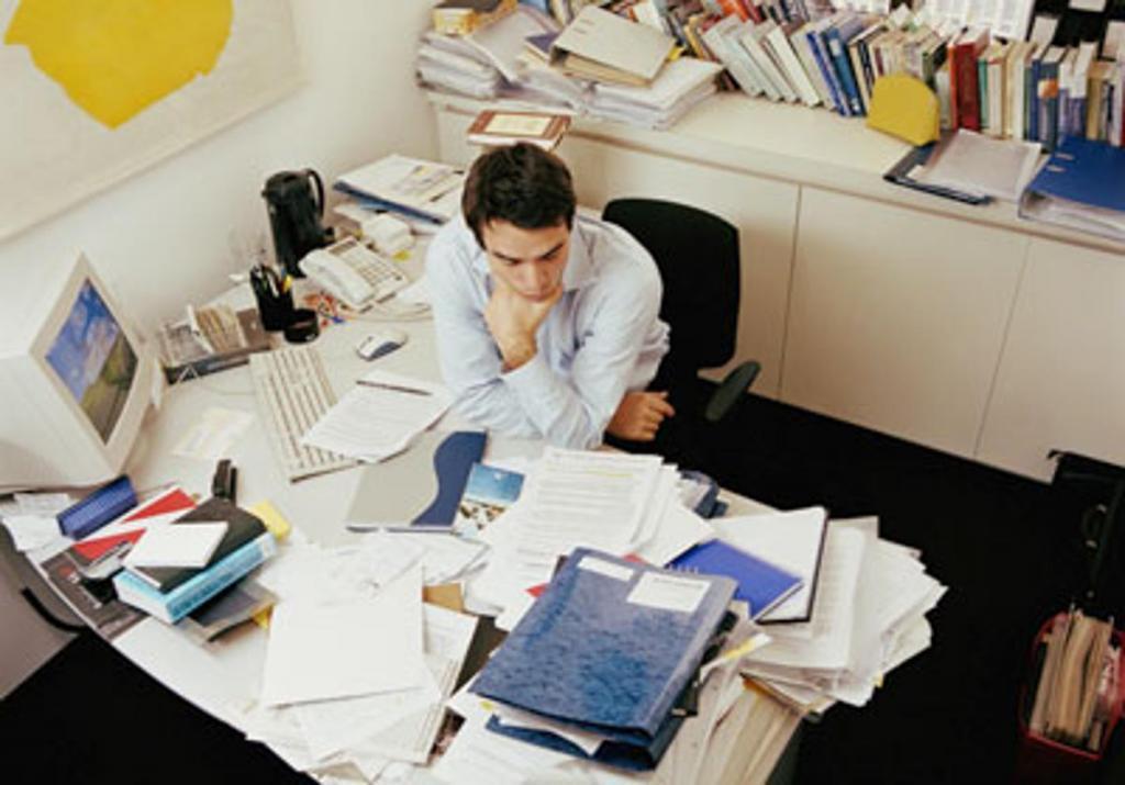 Office papers. Письменный стол заваленный бумагами в офисе. Бумаги на столе. Бардак на рабочем месте. Офис люди бумага.
